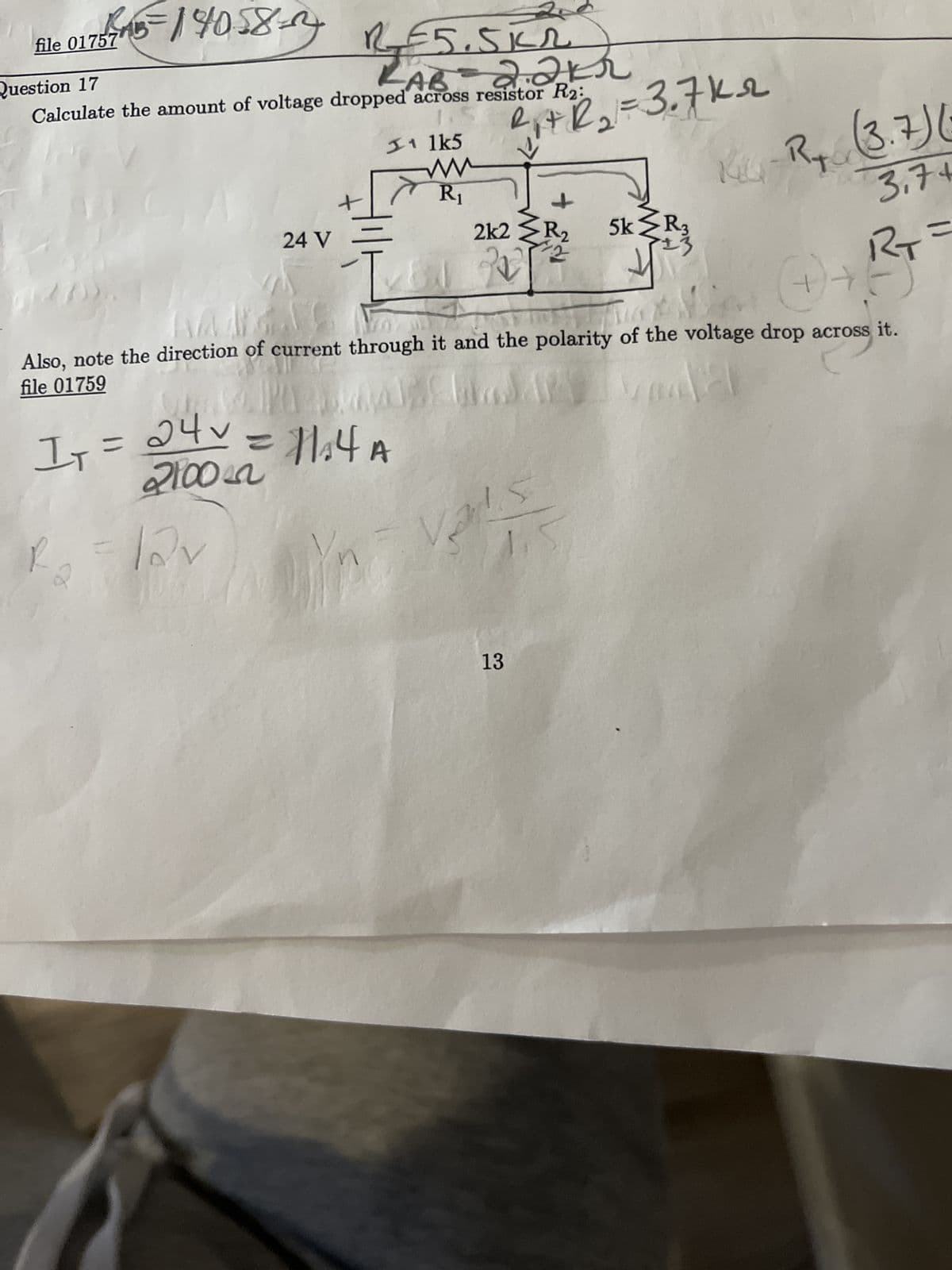 file 017577115=114058-
Question 17
AB
2.211
Calculate the amount of voltage dropped across resistor R2:
#ww
24 V
VISSU
R₁ = lov
11 lk5
f
IT
1₁ = 24V = 11₁4 A
2100
ww
R₁
R₁+R₂ = 3.7k₂
↑
2k2 >R₂
42
Also, note the direction of current through it and the polarity of the voltage drop across it.
file 01759
Van
Mat Chadar
ارحوا
t
1.5
13
5k >R3
R₁ (3.7)
3.74
RT=
BI
(+) + !