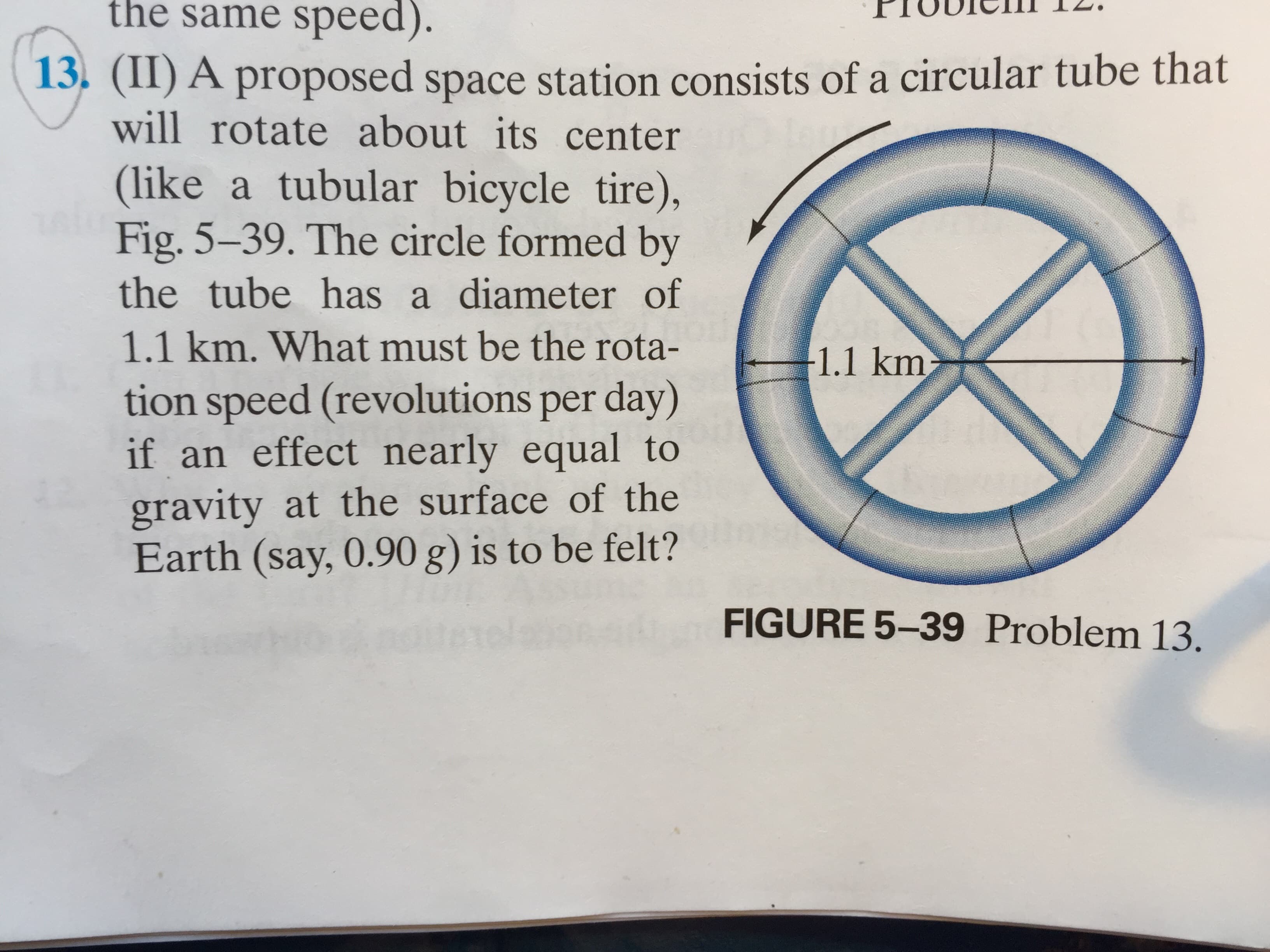 the same speed).
13. (II) A proposed space station consists ofa circular tube that
will rotate about its center
(like a tubular bicycle tire),
Fig. 5-39. The circle formed by
the tube has a diameter of
1.1 km. What must be the rota-
1.1 km
tion speed (revolutions per day)
if an effect nearly equal to
gravity at the surface of the
Earth (say, 0.90 g) is to be felt?
FIGURE 5-39 Problem 13.
