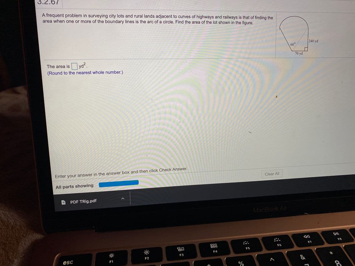 3.2.67
A frequent problem in surveying city lots and rural lands adjacent to curves of highways and railways is that of finding the
area when one or more of the boundary lines is the arc of a circle. Find the area of the lot shown in the figure.
240 yd
60°.
The area is yd.
(Round to the nearest whole number.)
70 yd
Enter your answer in the answer box and then click Check Answer.
All parts showing
Clear All
PDF TRig.pdf
MacBook Air
吕0
ס
F8
F7
F5
F6
F4
esc
F2
F3
F1
.....
