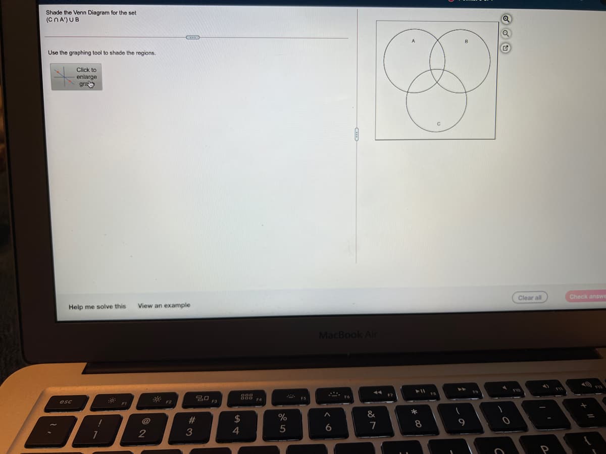 Shade the Venn Diagram for the set
(CNA') UB
B
Use the graphing tool to shade the regions.
Click to
enlarge
gra
Clear all
Check answ
Help me solve this
View an example
MacBook Air
F10
F1
@
23
$
%
7
8
9
2
3
5
