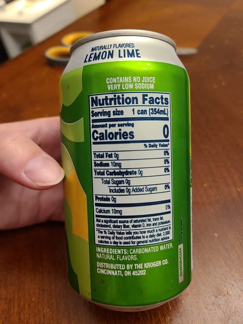 NATURALLY FLAVORED
LEMON LIME
CONTAINS NO JUICE
VERY LOW SODIUM
Nutrition Facts
Serving size 1 can (354mL)
Amount per serving
Calories
% Daily Value
Total Fat Og
Sodium 10mg
Total Carbohydrate Og
Total Sugars Og
Protein Og
Calcium 10mg
0%
Includes Og Added Sugars 0%
0%
Not a significant source of saturated fat,
cholesterol, dietary fiber, vitamin D, iron and potassium
"The % Daily Value tells you how much a nutrient in
a serving of food contributes to a daily diet 2,000
calories a day is used for general nutrition advice
INGREDIENTS: CARBONATED WATER
NATURAL FLAVORS
DISTRIBUTED BY THE KROGER CO.
CINCINNATI, OH 45202
169950
VODYBRODZE