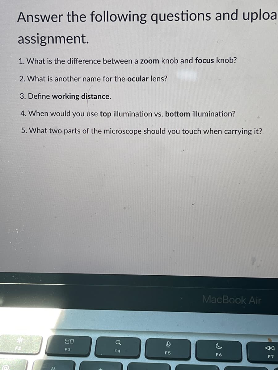 Answer the following questions and uploa
assignment.
1. What is the difference between a zoom knob and focus knob?
2. What is another name for the ocular lens?
3. Define working distance.
4. When would you use top illumination vs. bottom illumination?
5. What two parts of the microscope should you touch when carrying it?
MacBook Air
吕0
F3
F4
F5
F6
F7
