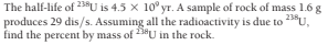 The half-life of 23U is 4.5 x 10° yr. A sample of rock of mass 1.6 g
produces 29 dis/s. Assuming all the radioactivity is due to 23®U,
find the percent by mass of 23*U in the rock.
