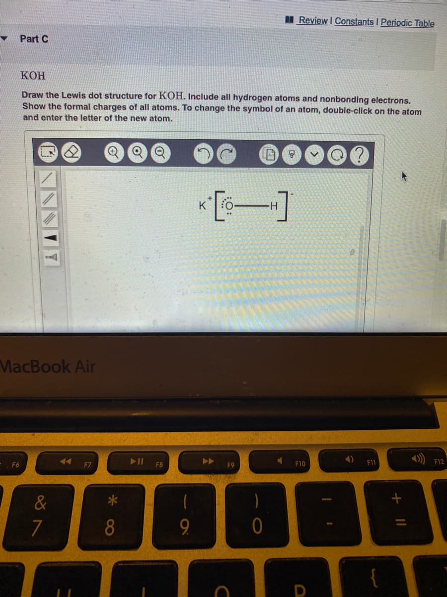 I Review I Constants I Periodic Table
Part C
КОН
Draw the Lewis dot structure for KOH. Include all hydrogen atoms and nonbonding electrons.
Show the formal charges of all atoms. To change the symbol of an atom, double-click on the atom
and enter the letter of the new atom.
*[s-]
K
H.
MacBook Air
F6
F8
F9
F10
F11
F12
&
7
8
9.
D
